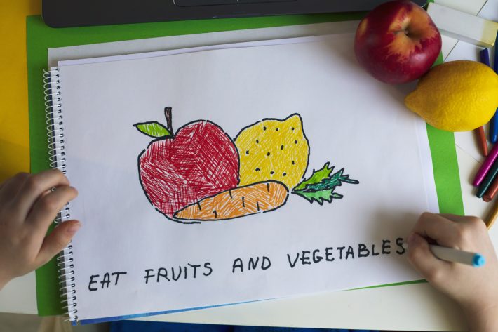 Little child drawing. Antiviral foods to build immunity and keep diseases away. Vitamins. Preschool age education.